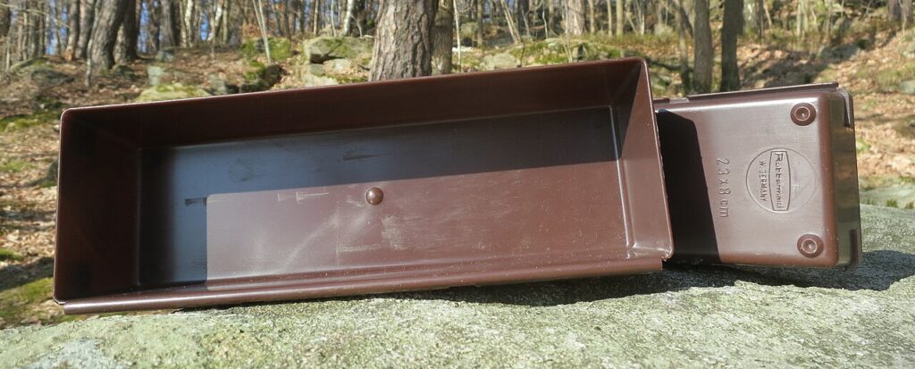 Two brown rectangular plastic drawer organizer trays, one showing its empty interior and the other its underside.